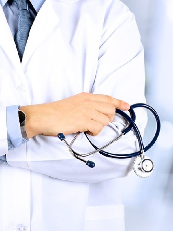 Portrait an unknown male doctor holding a stethoscope behind